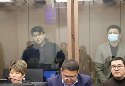 Сот Қуандық Бишімбаевтың ұялы телефонын тексеріп жатыр